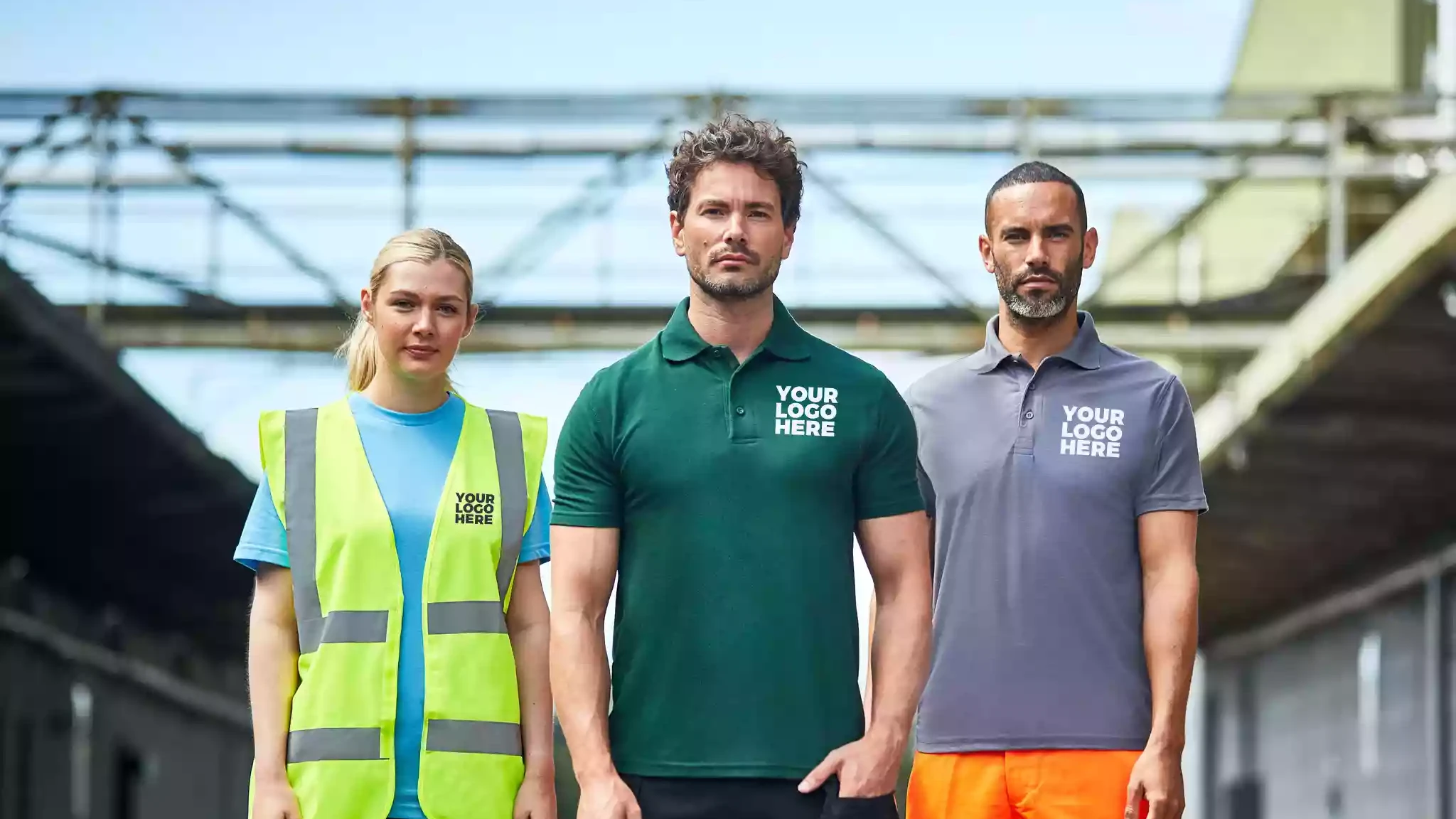 Three people stood in various workwear with "Your Logo Here" on, showing they can be customised